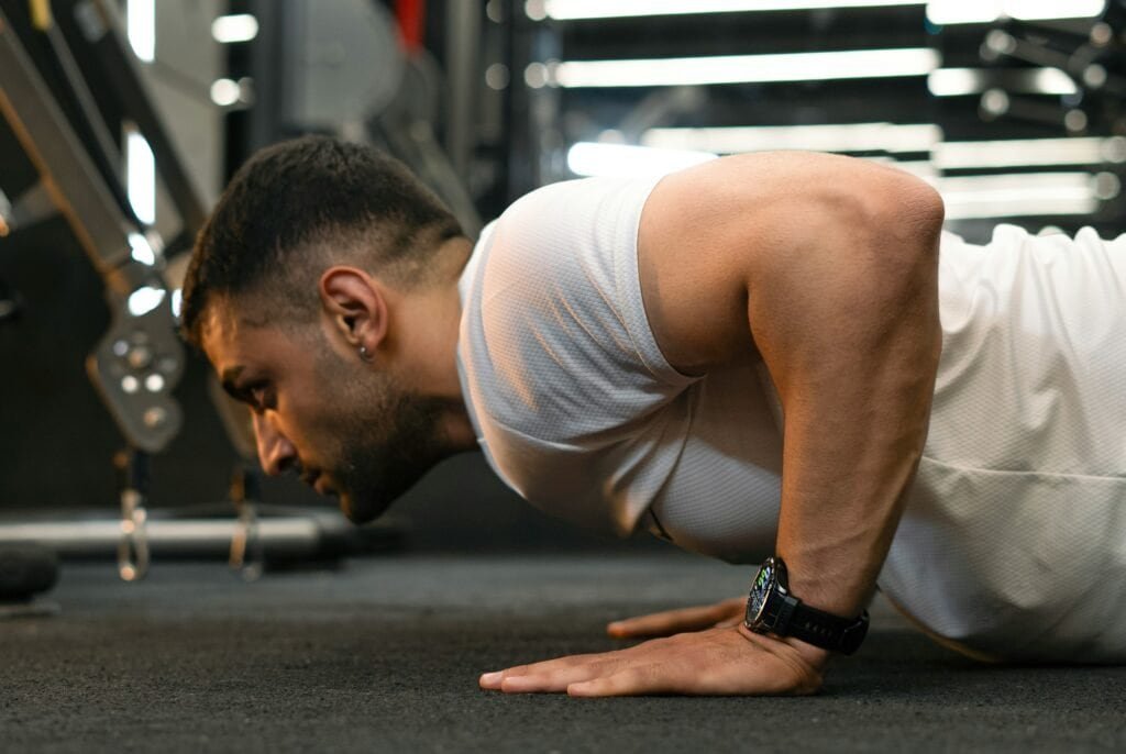 man performing push up exercise as part of a progressive overload program