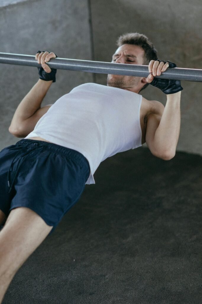 person performing an inverted row using bodyweight on a low bar to train upper body muscles